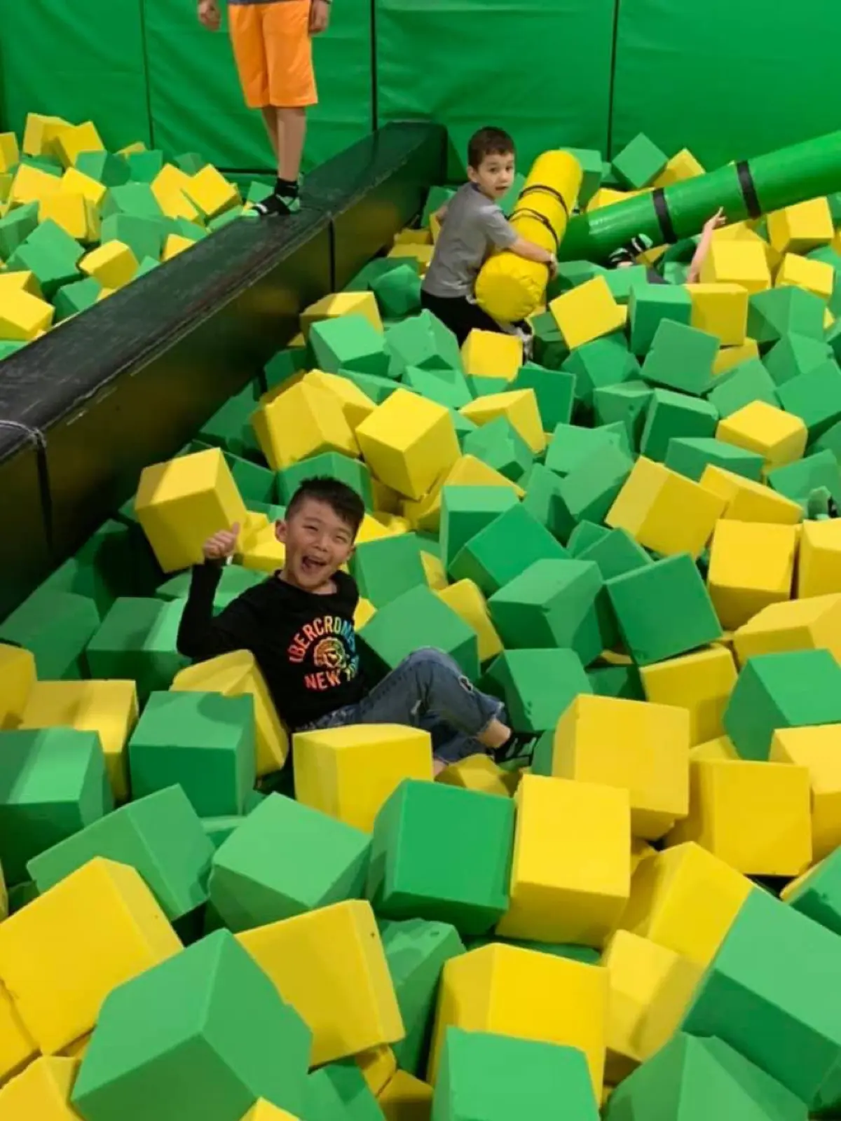 Summer campers in a foam pit on a trampoline-park field trip