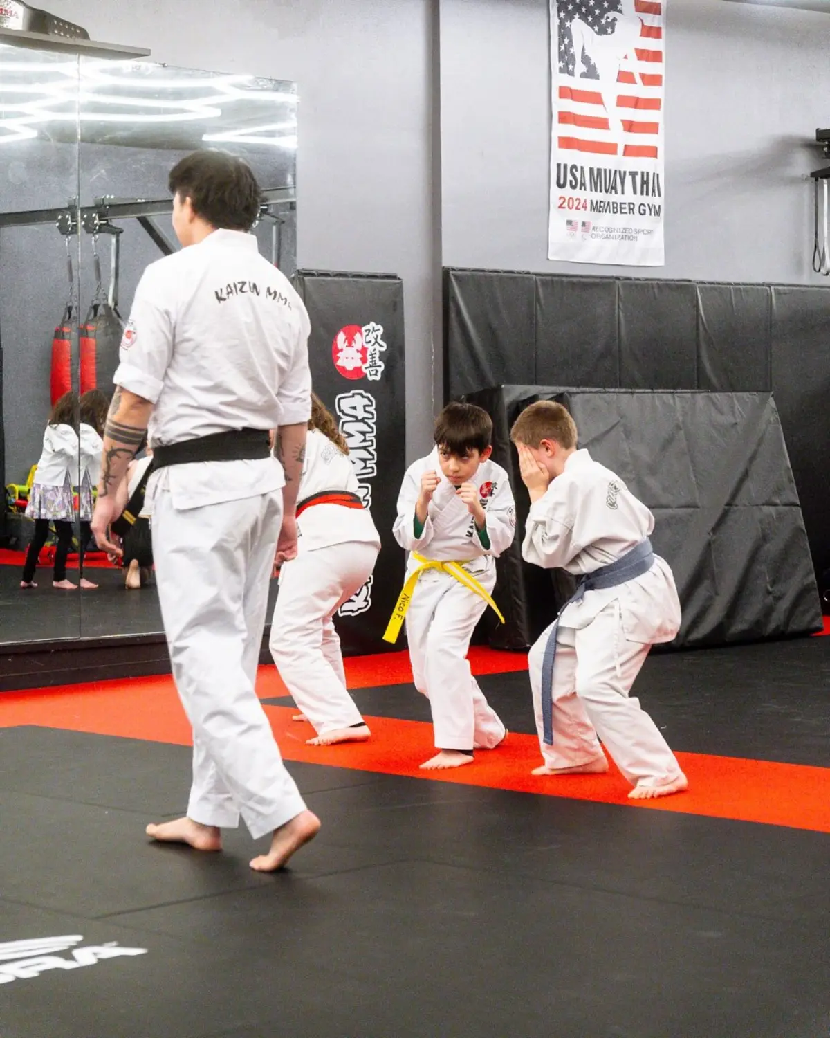 Kids sparring with their instructor at Kaizen MMA