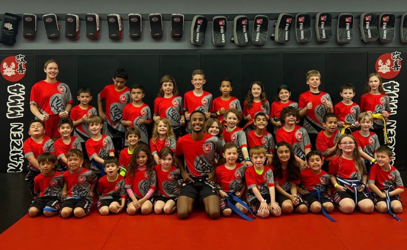 Coach and the kids martial arts class together on the mats at Kaizen MMA South Riding