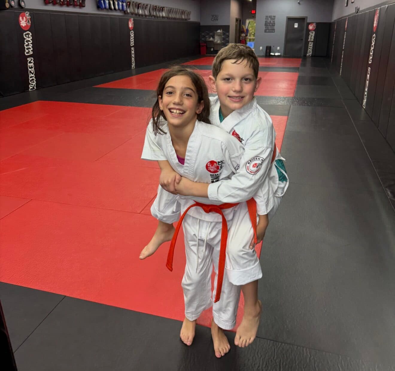 Two Young Lions students laughing together on the mats at Kaizen MMA South Riding